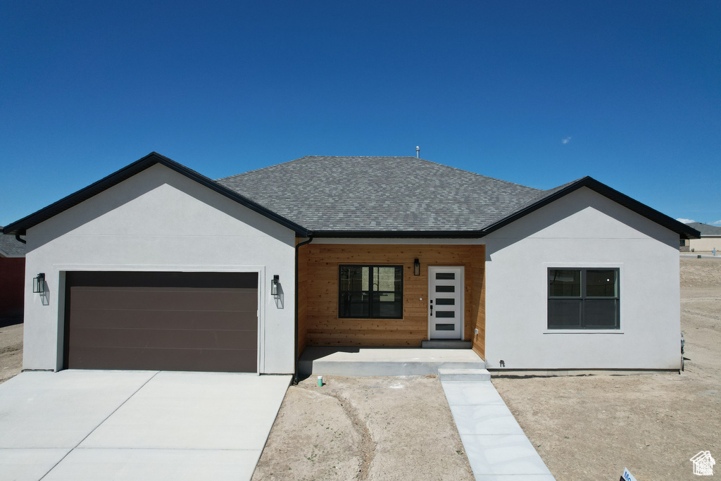 View of front of home with a porch and a garage