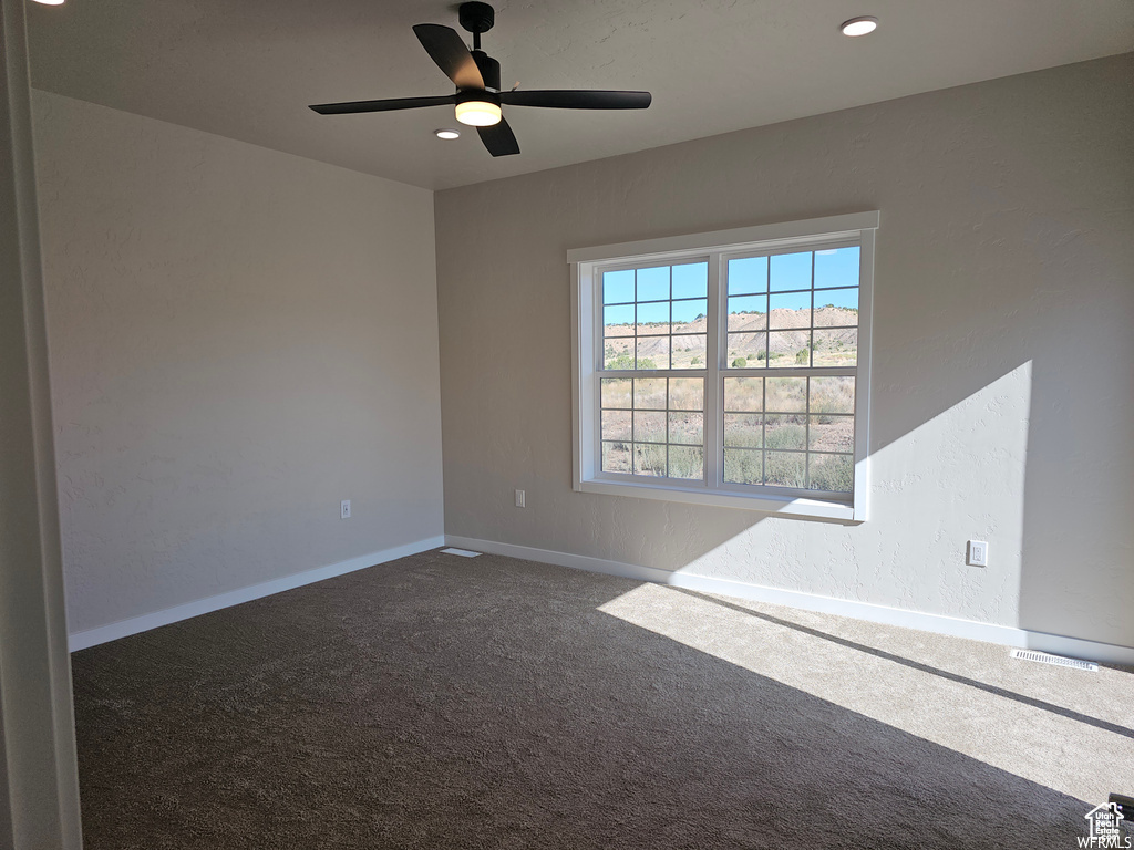 Empty room featuring carpet flooring and ceiling fan