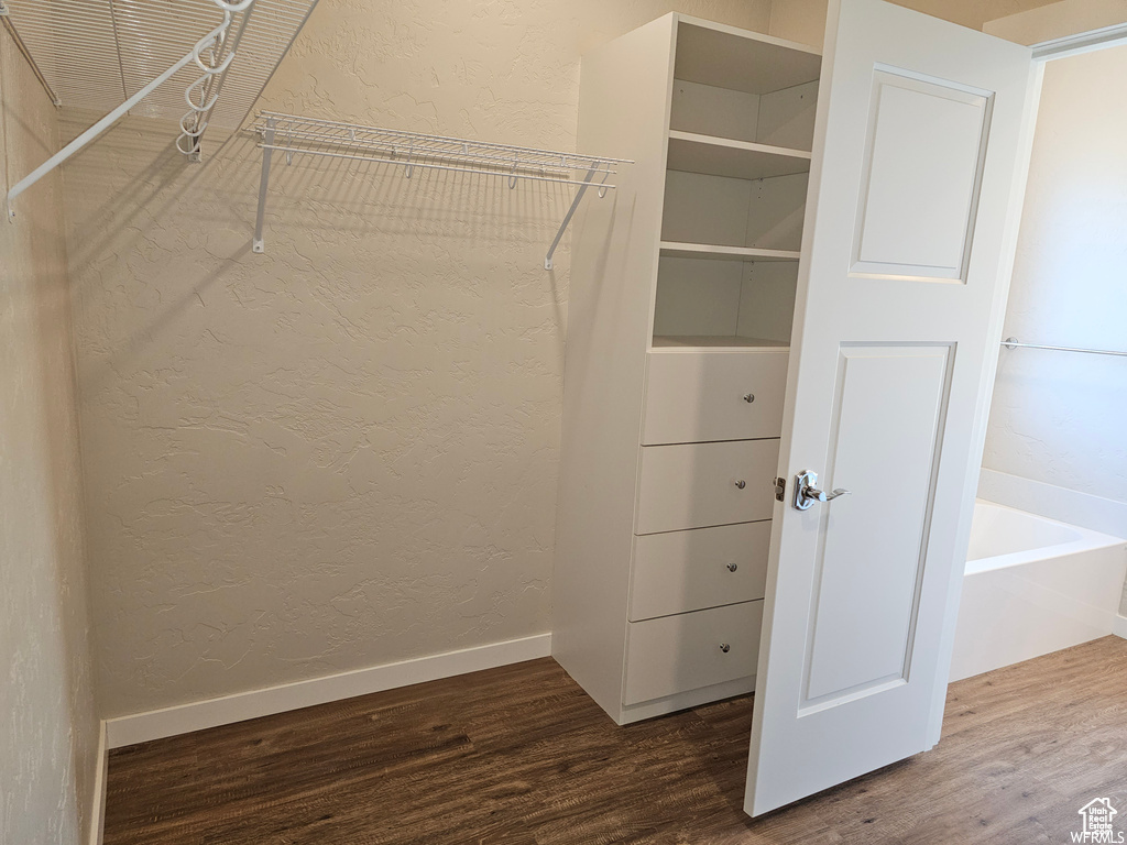 Walk in closet with wood-type flooring