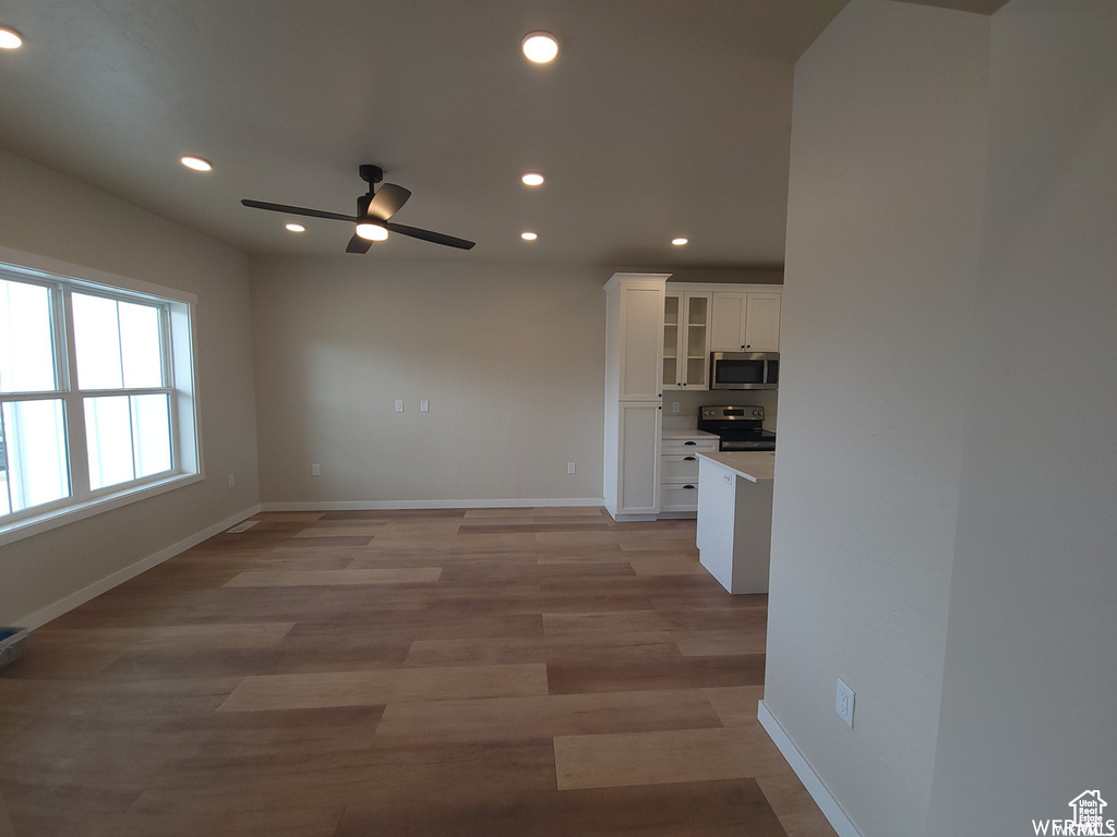 Interior space with ceiling fan and light hardwood / wood-style floors