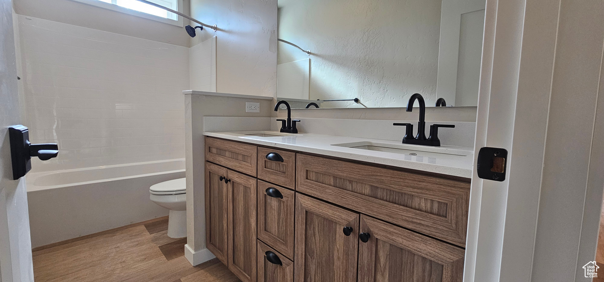 Full bathroom featuring hardwood / wood-style flooring, vanity,  shower combination, and toilet