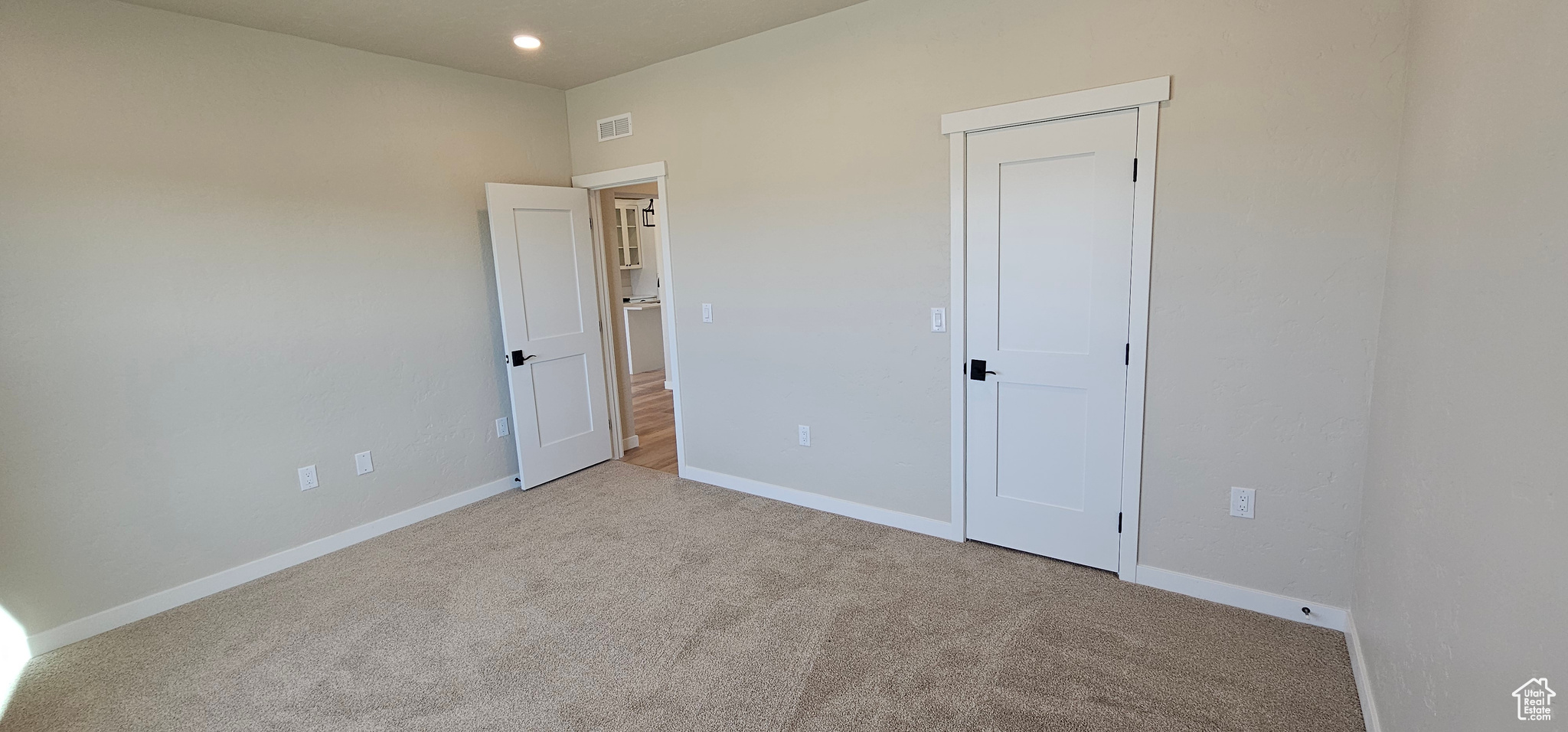 Unfurnished bedroom featuring light colored carpet