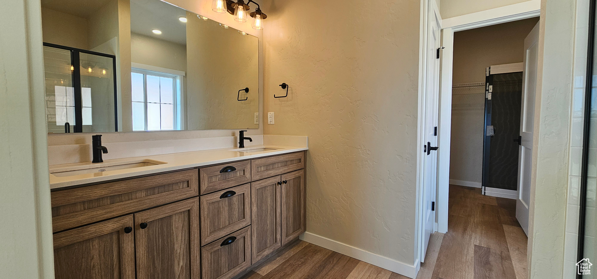 Bathroom with vanity, a shower with shower door, and hardwood / wood-style flooring