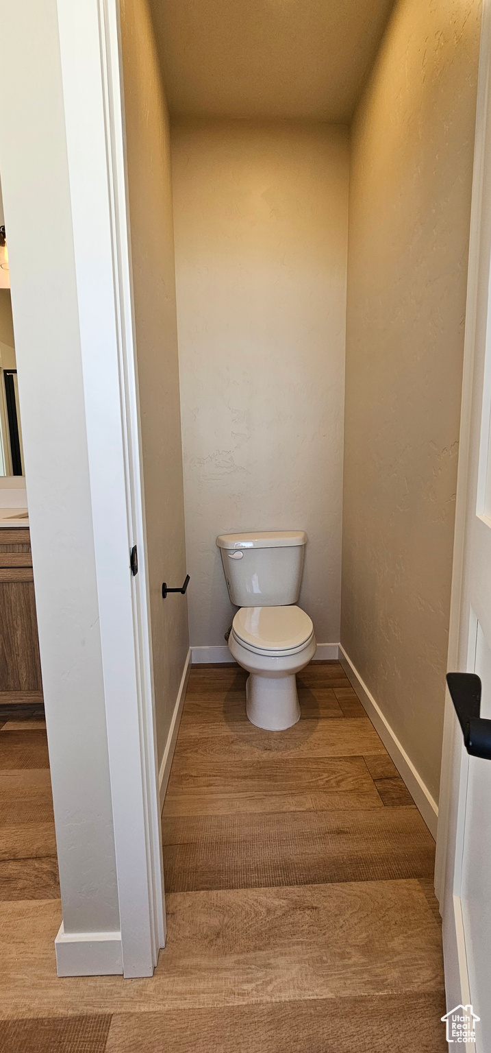 Bathroom featuring hardwood / wood-style flooring and toilet