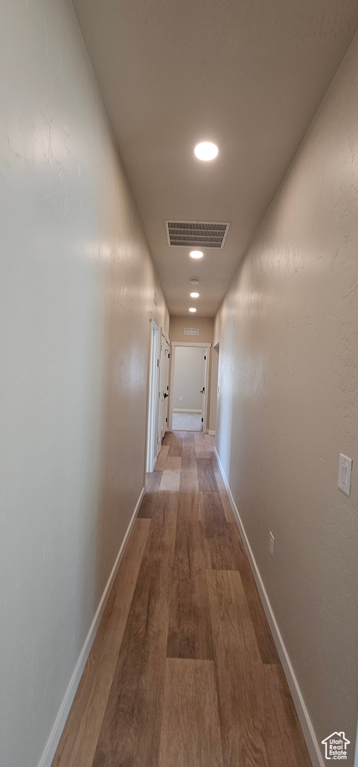 Corridor with hardwood / wood-style floors