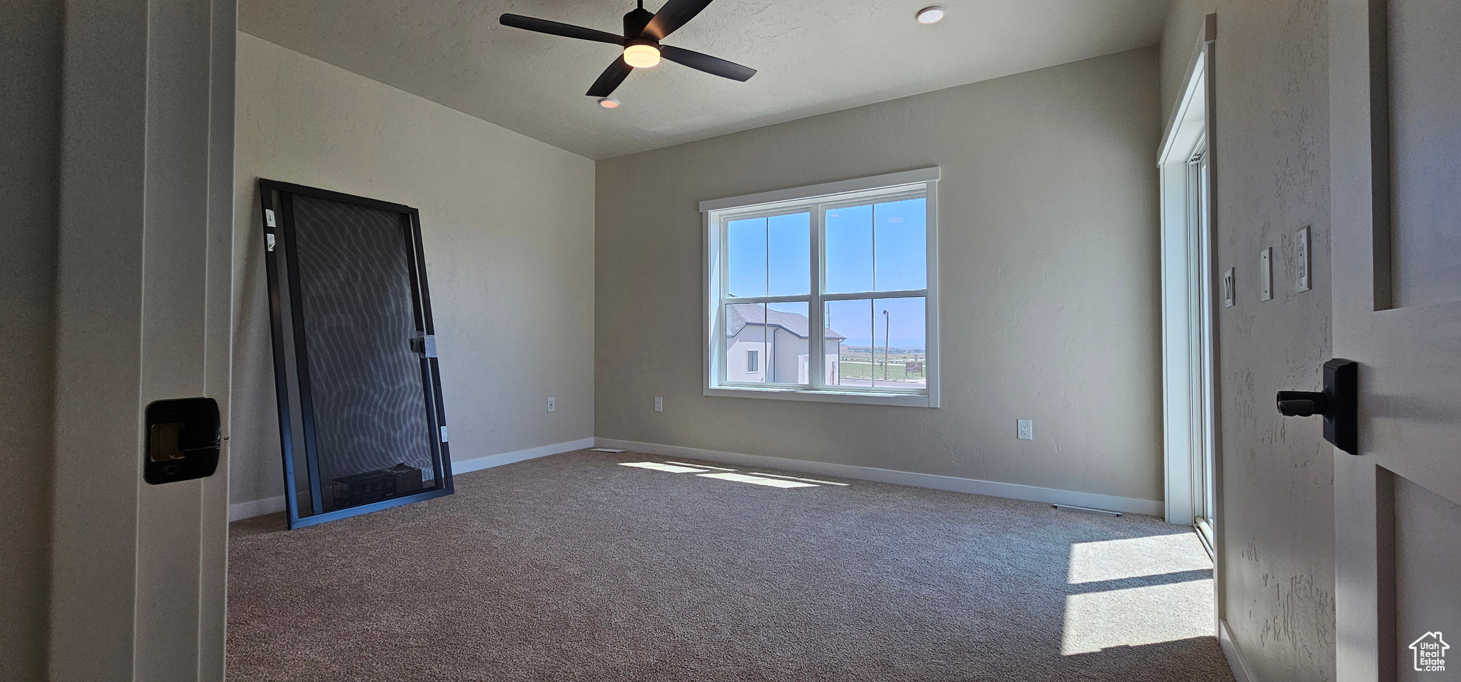 Spare room featuring carpet flooring and ceiling fan