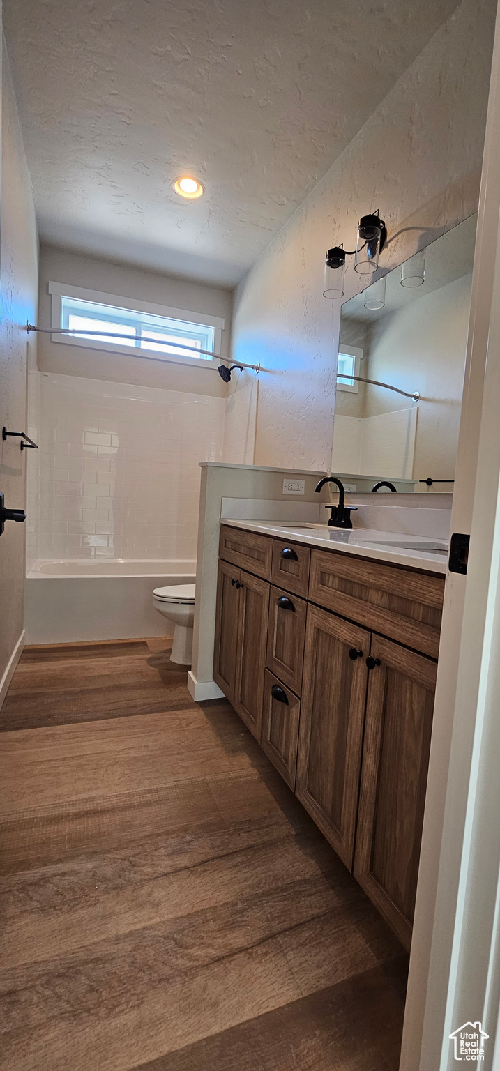 Full bathroom featuring shower / bathing tub combination, vanity, toilet, and wood-type flooring