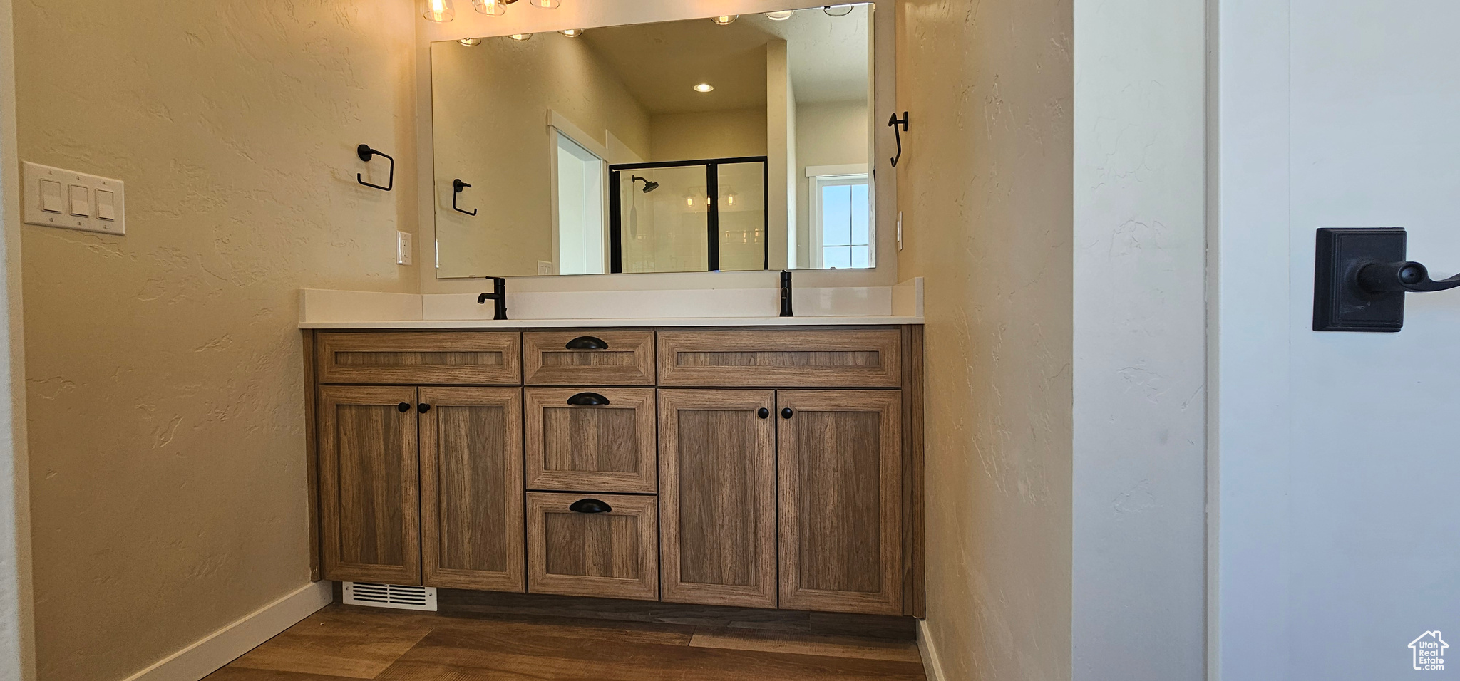 Bathroom with vanity, an enclosed shower, and hardwood / wood-style flooring