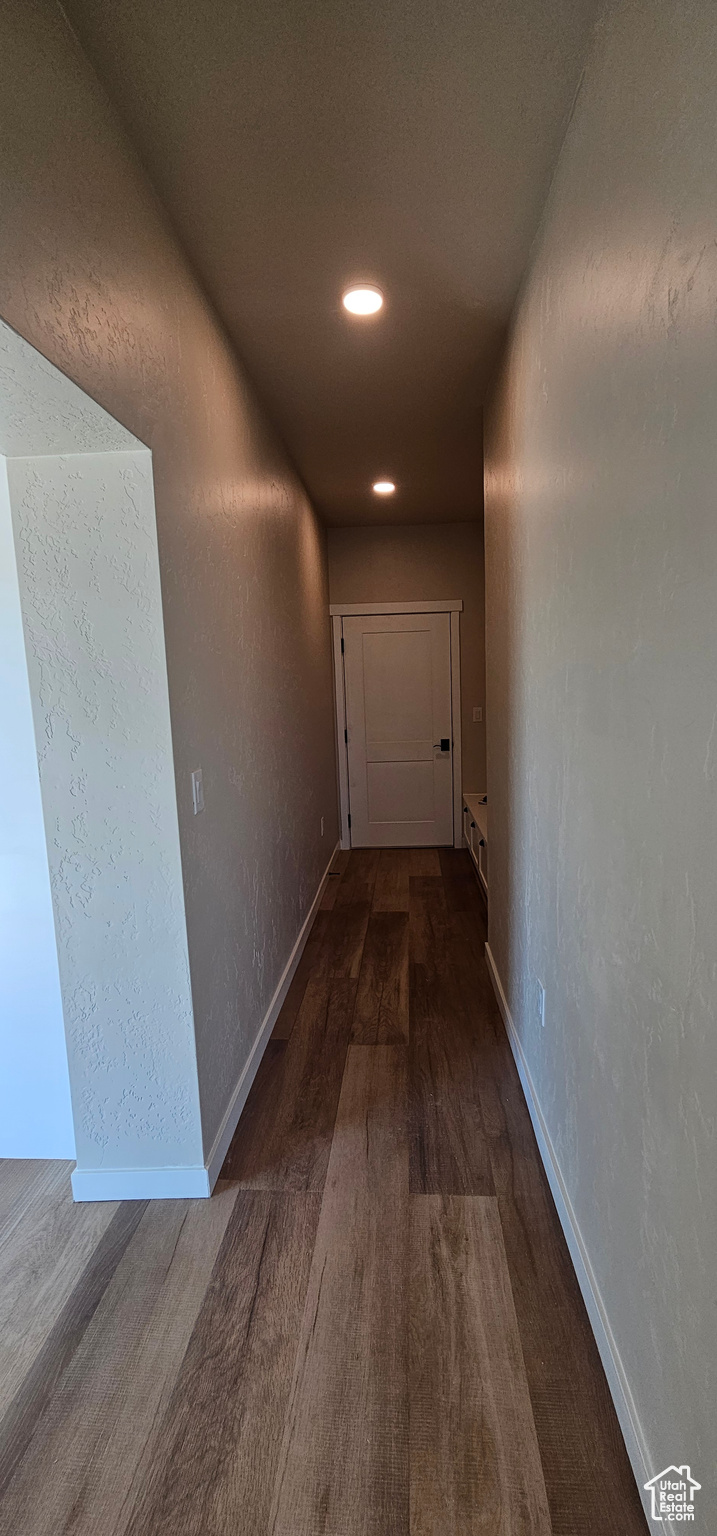 Hallway with dark hardwood / wood-style floors