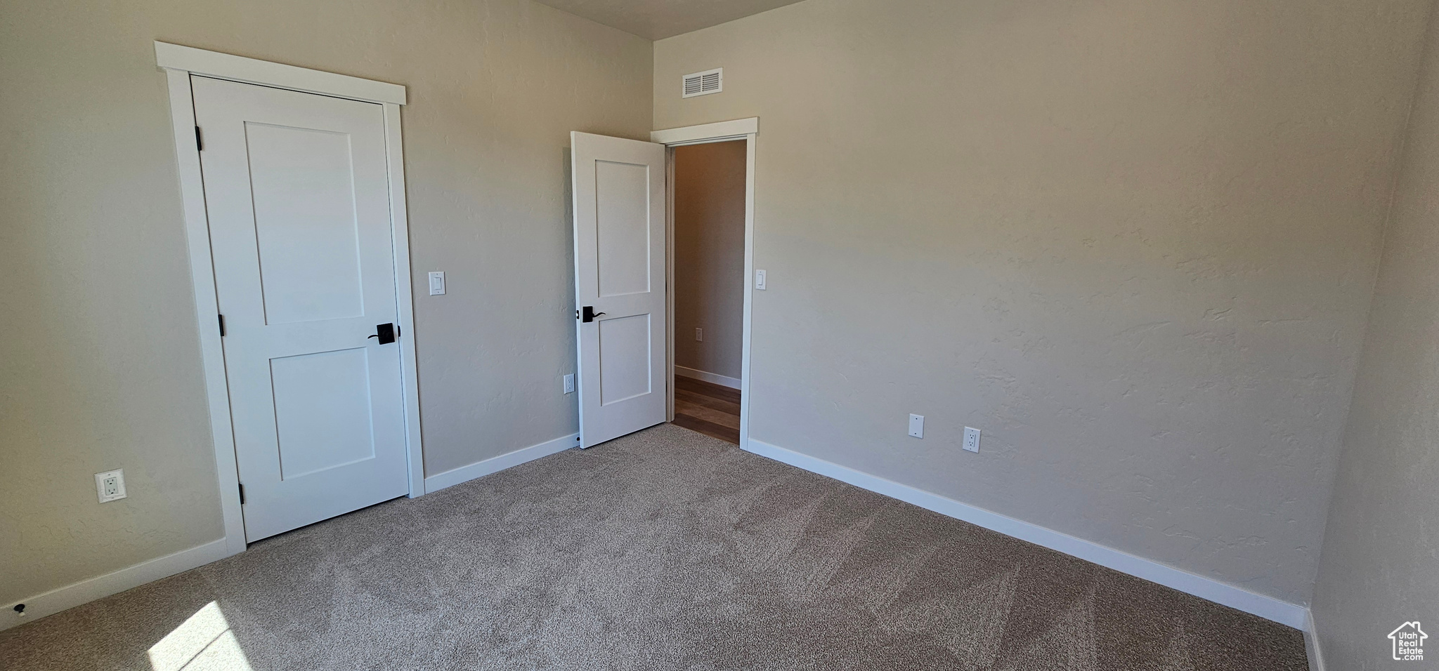 Unfurnished bedroom featuring light colored carpet