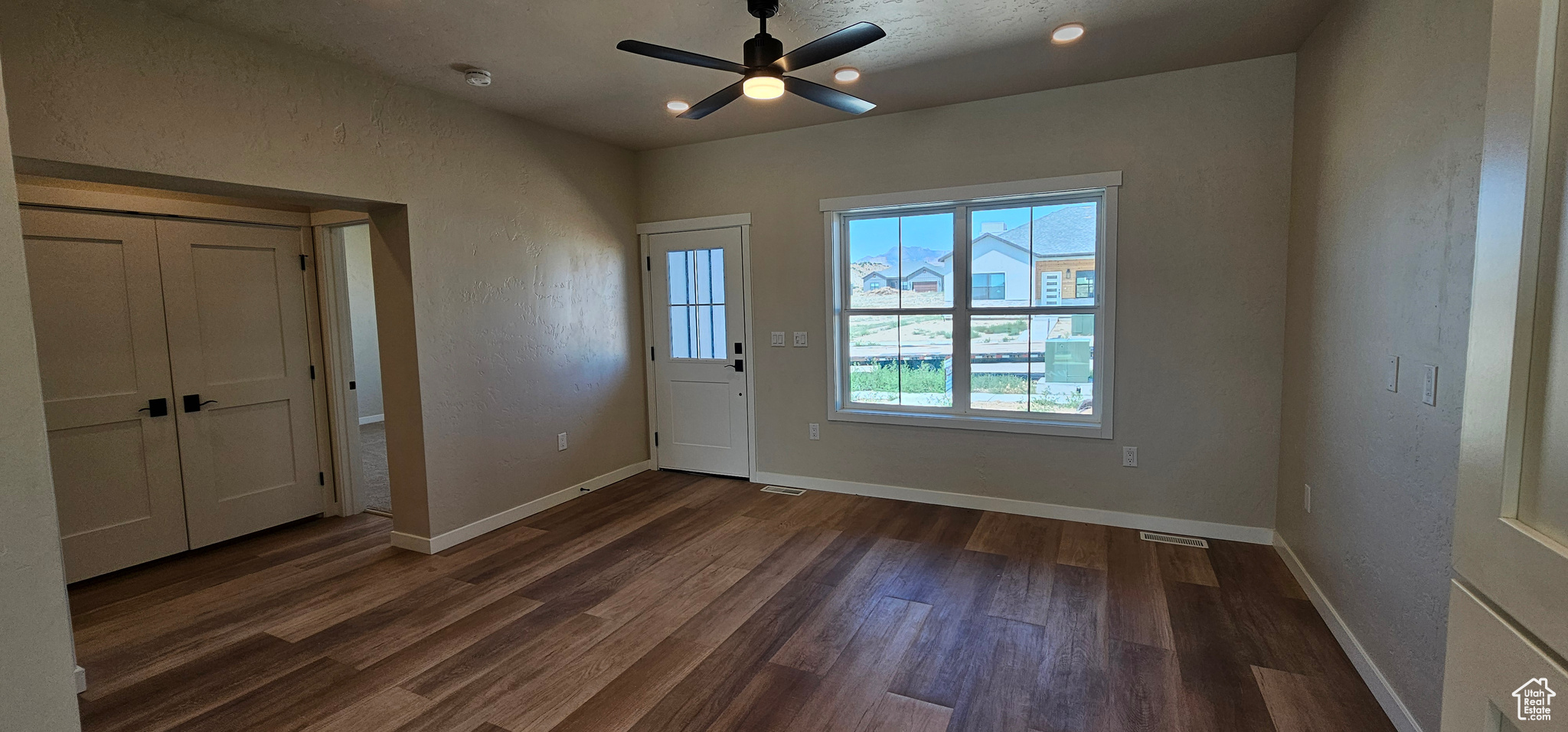 Interior space featuring ceiling fan and dark hardwood / wood-style floors