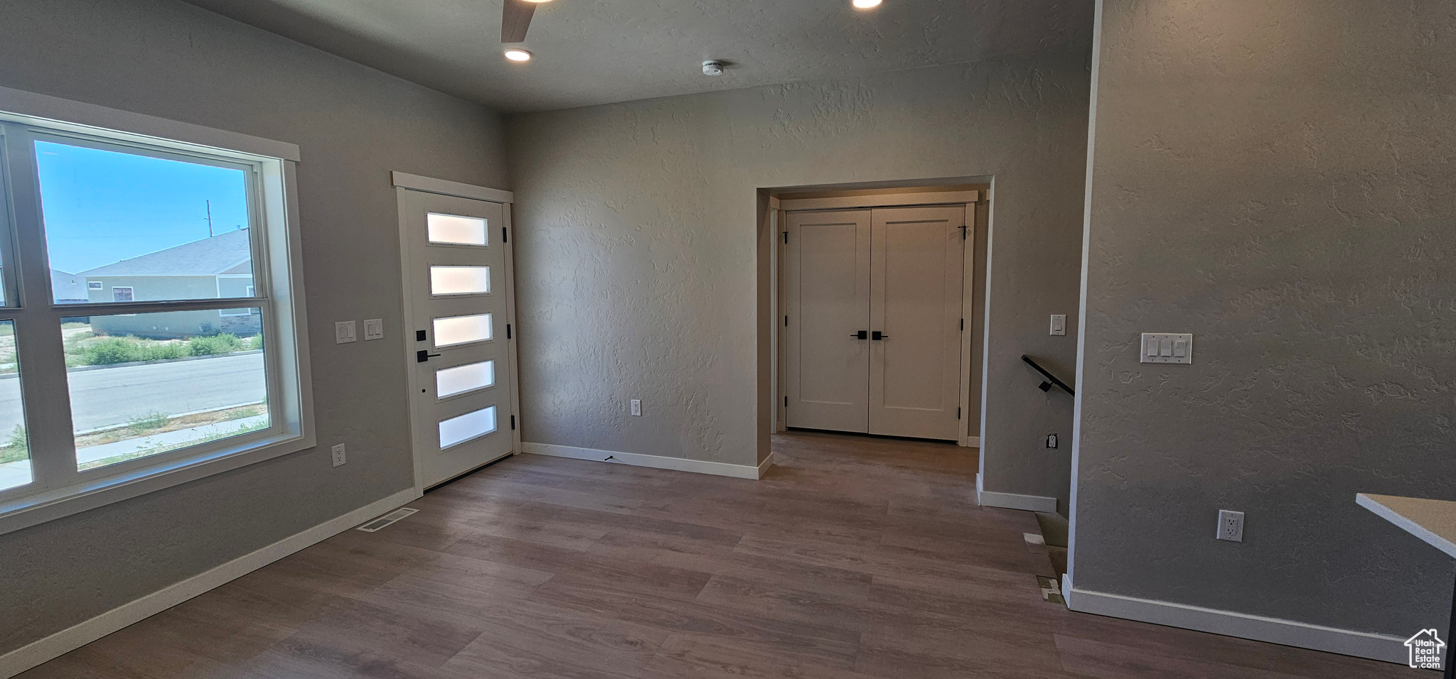 Foyer with light hardwood / wood-style floors, plenty of natural light, and ceiling fan