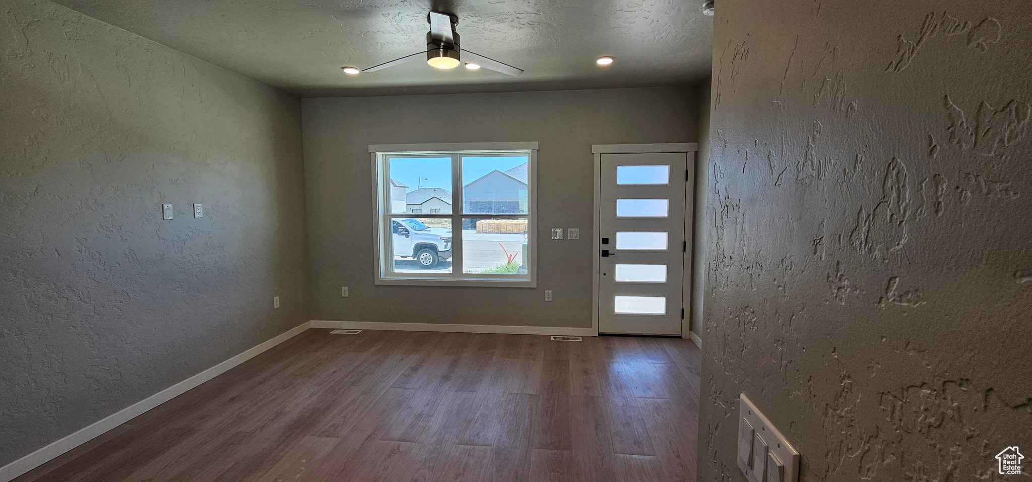 Interior space featuring ceiling fan, wood-type flooring, and a textured ceiling