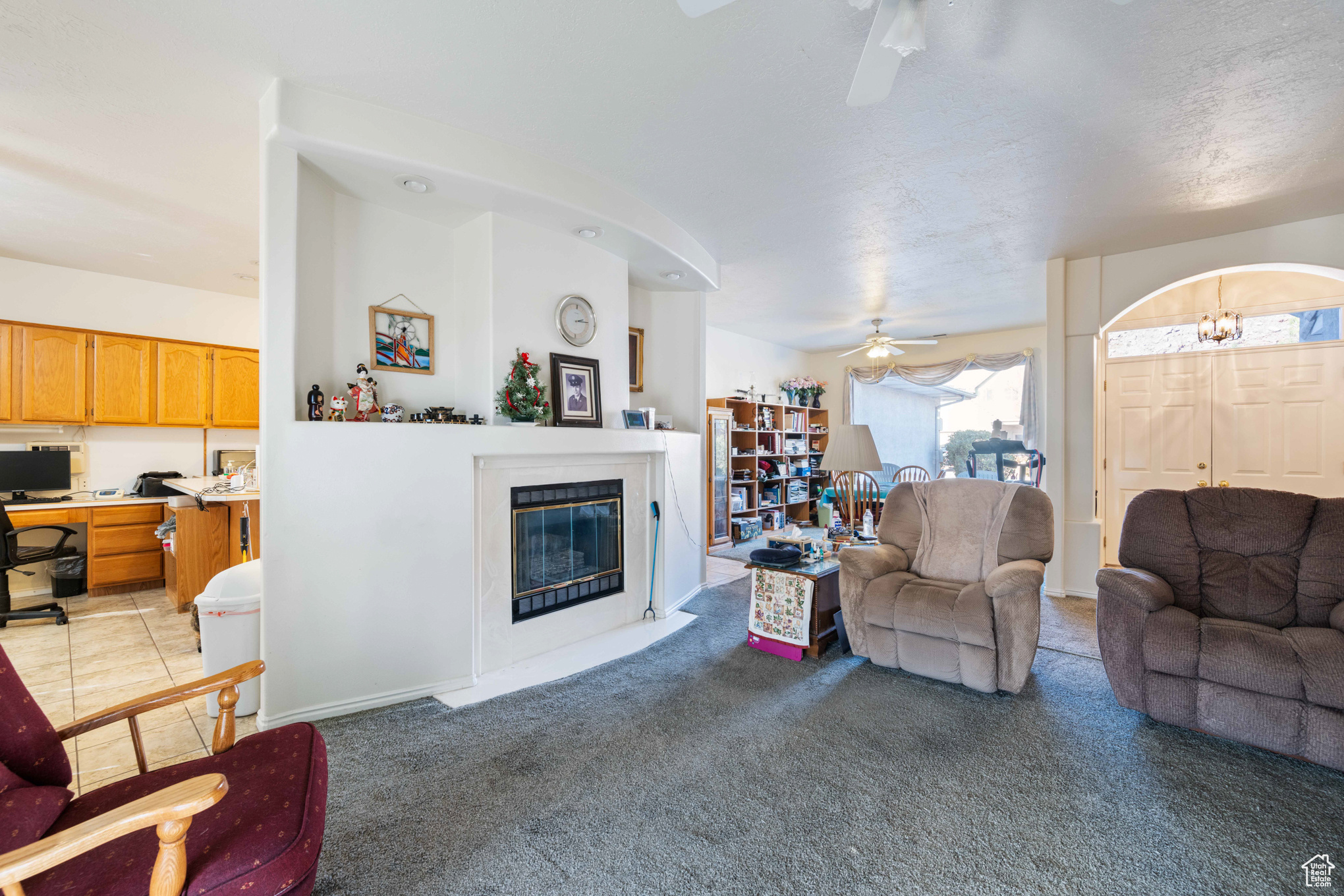 Living room featuring light carpet, a textured ceiling, and ceiling fan