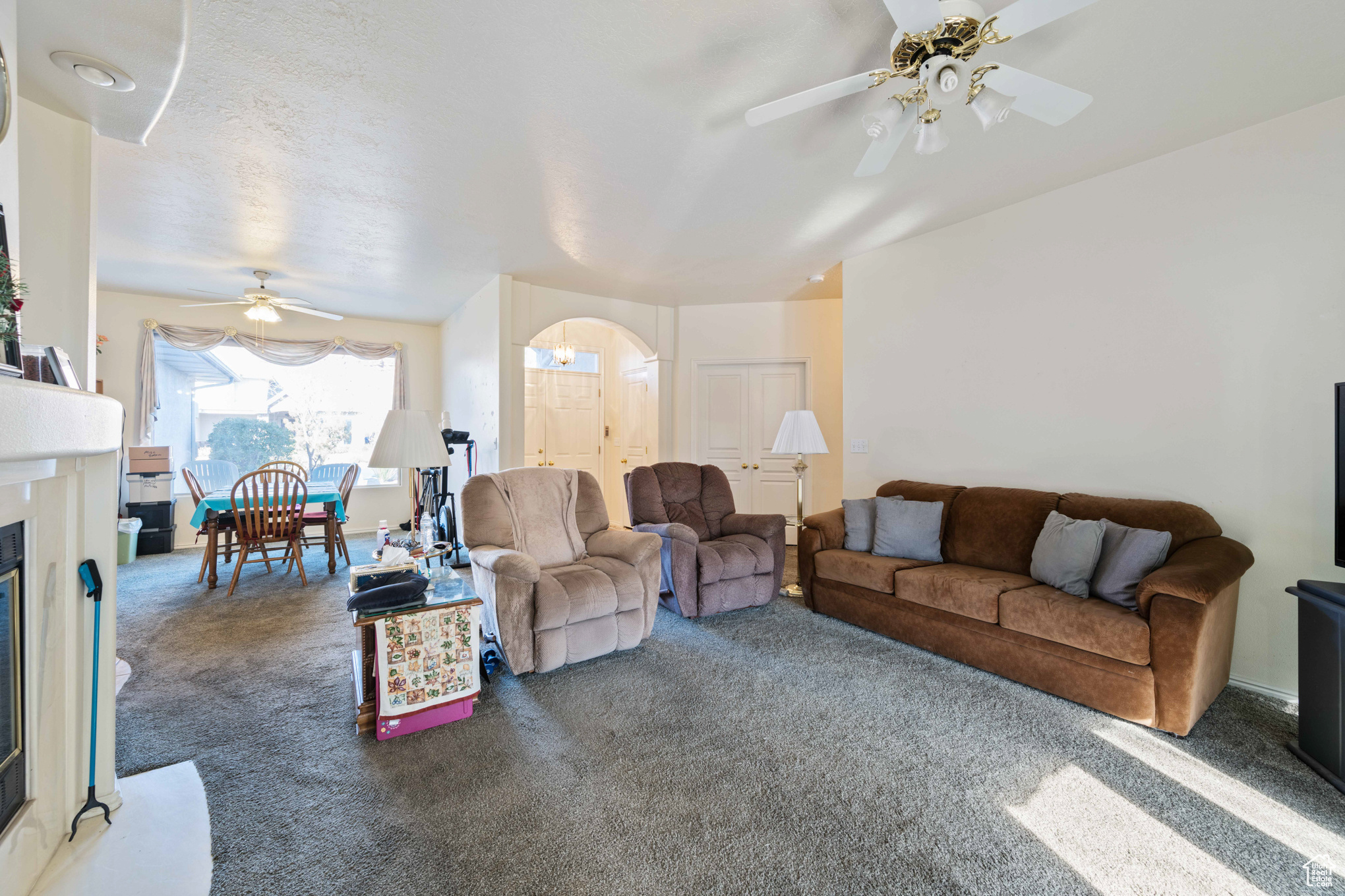 Living room with ceiling fan and dark carpet