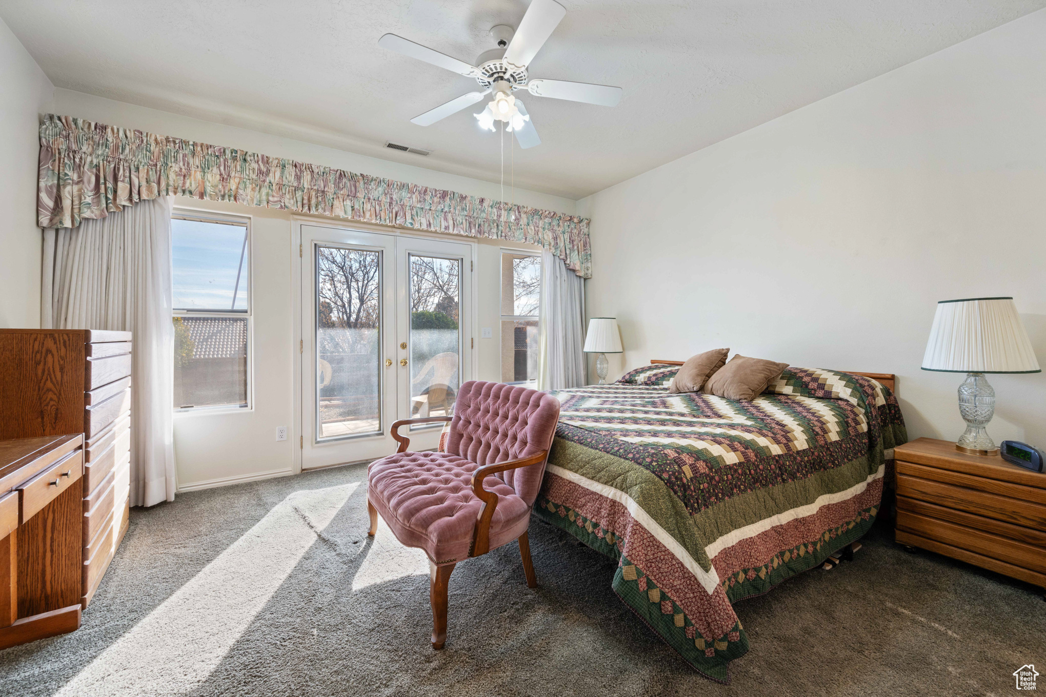 Carpeted bedroom featuring ceiling fan, access to exterior, and french doors