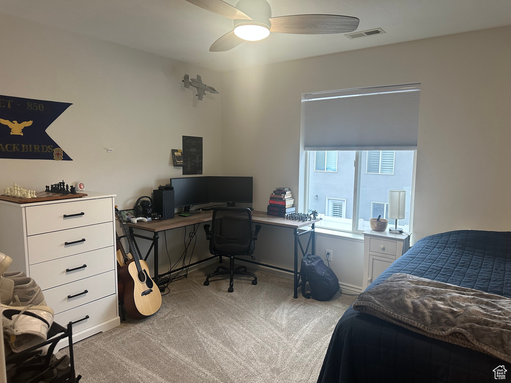 Carpeted bedroom featuring ceiling fan