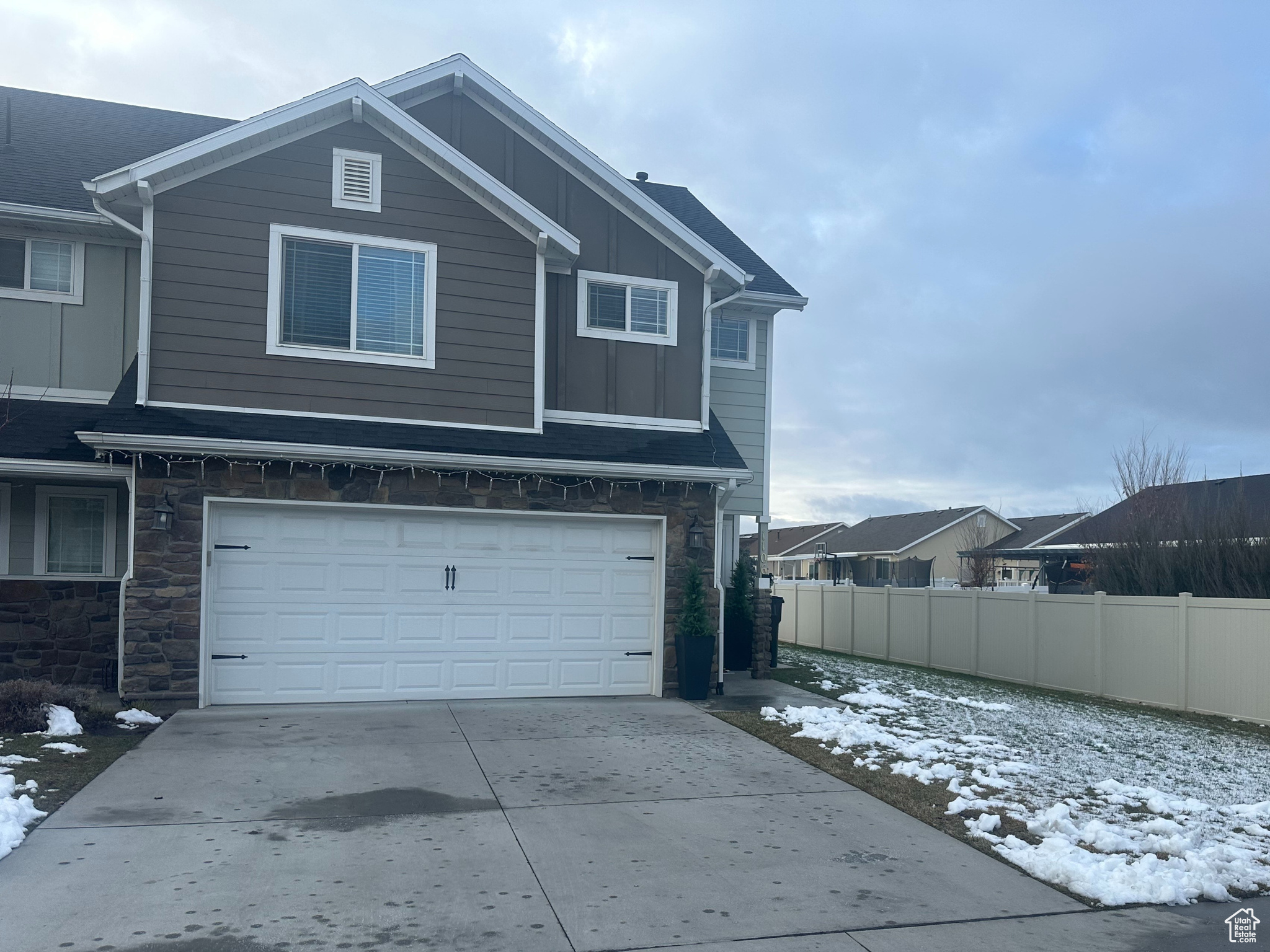 Snow covered property featuring a garage