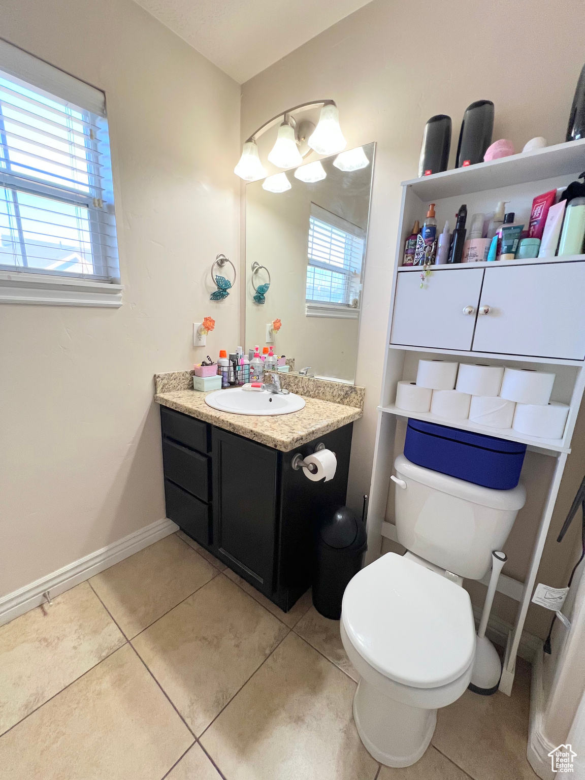 Bathroom featuring tile patterned flooring, vanity, a healthy amount of sunlight, and toilet