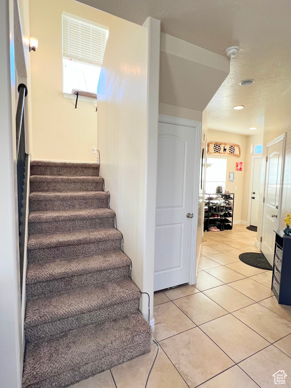 Staircase with tile patterned floors and plenty of natural light