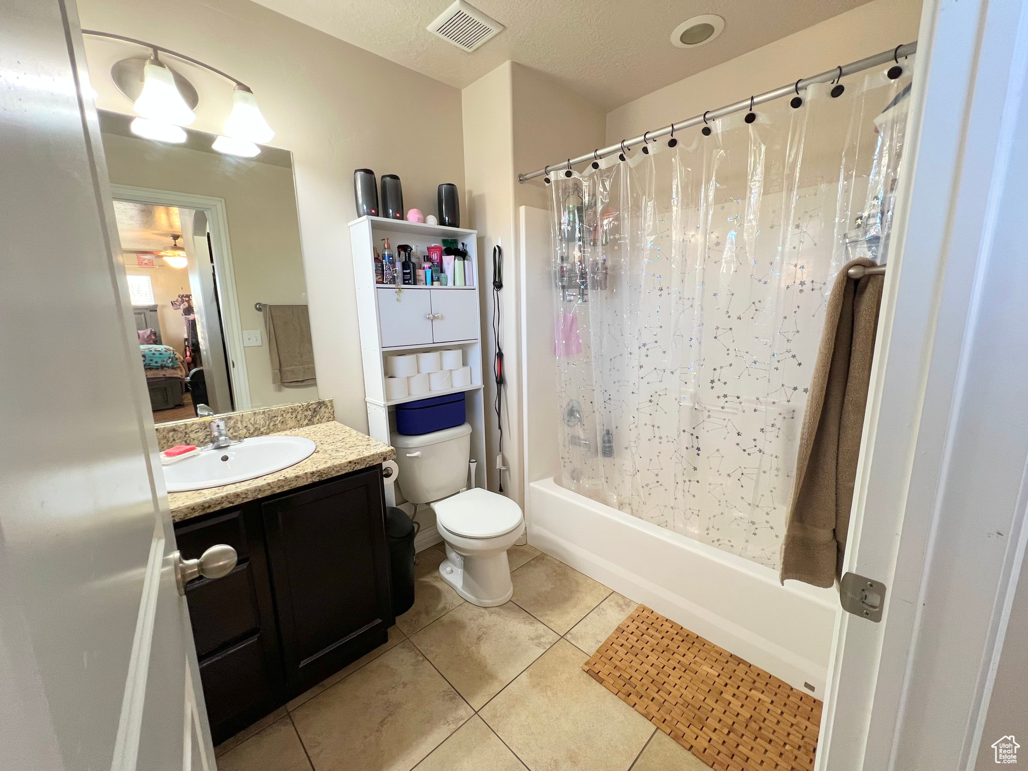 Full bathroom with tile patterned floors, vanity, shower / bath combination with curtain, and toilet