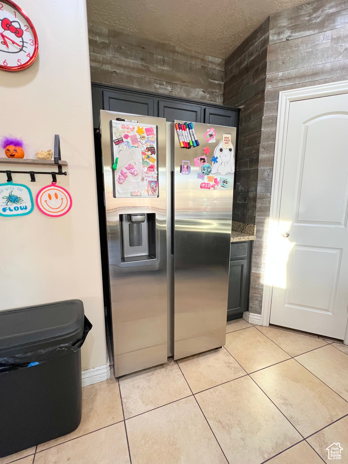 Kitchen featuring stainless steel fridge with ice dispenser, gray cabinets, and light tile patterned flooring