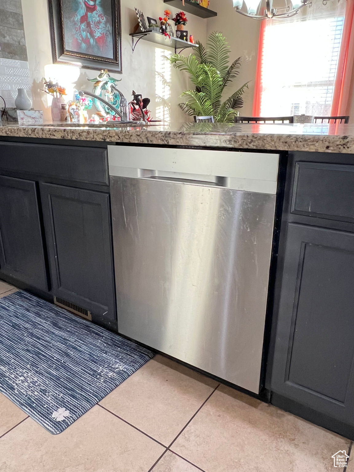 Kitchen featuring dishwasher and light tile patterned flooring