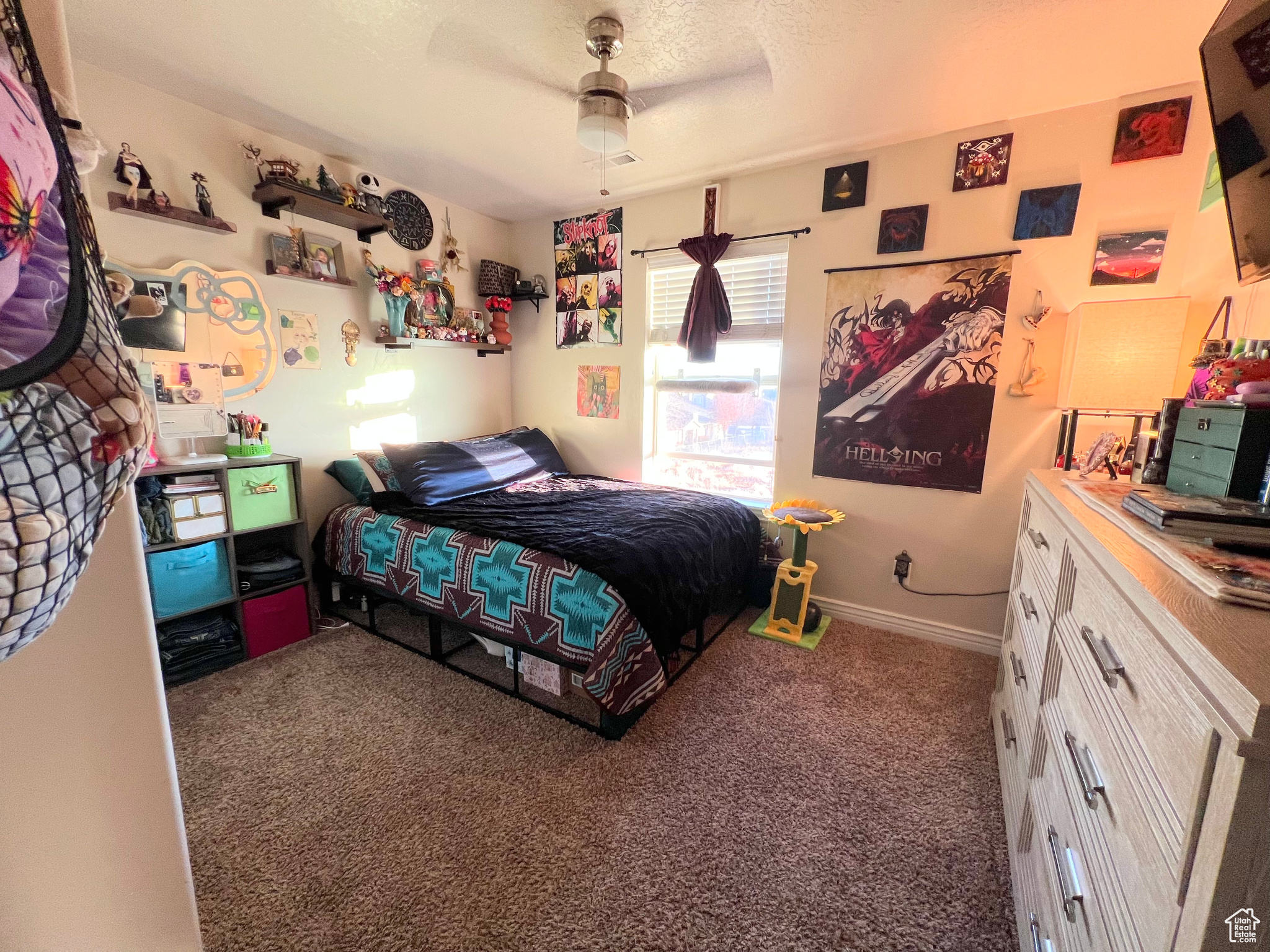 Carpeted bedroom with ceiling fan and a textured ceiling