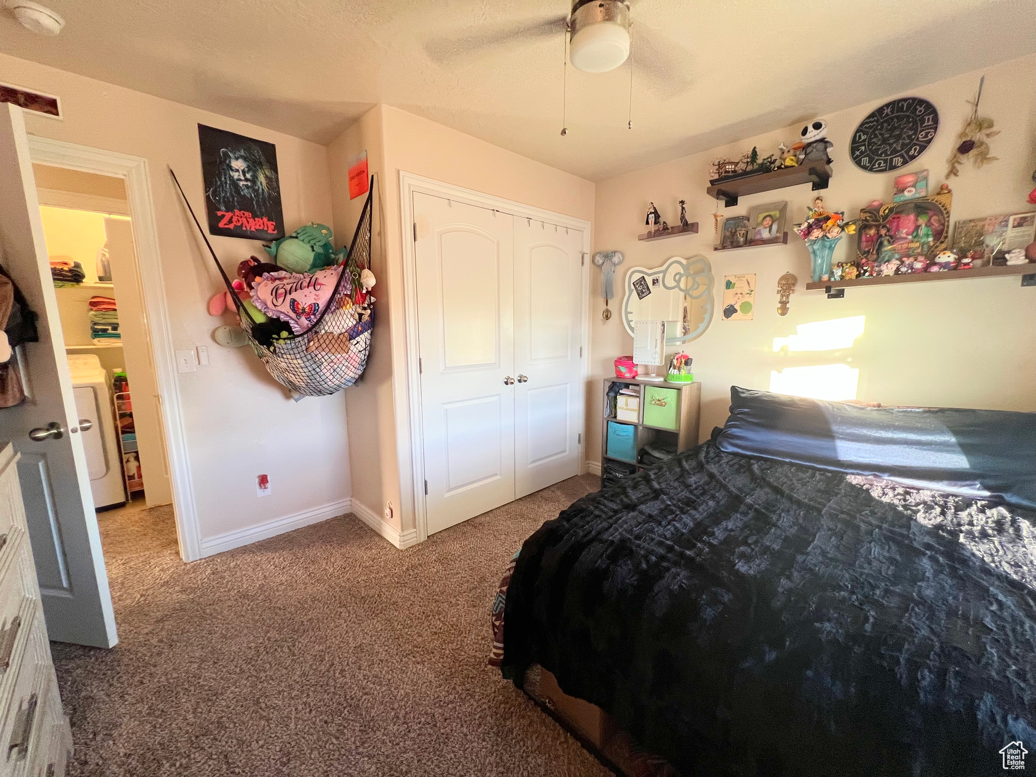 Carpeted bedroom with ceiling fan, a closet, and washer / dryer