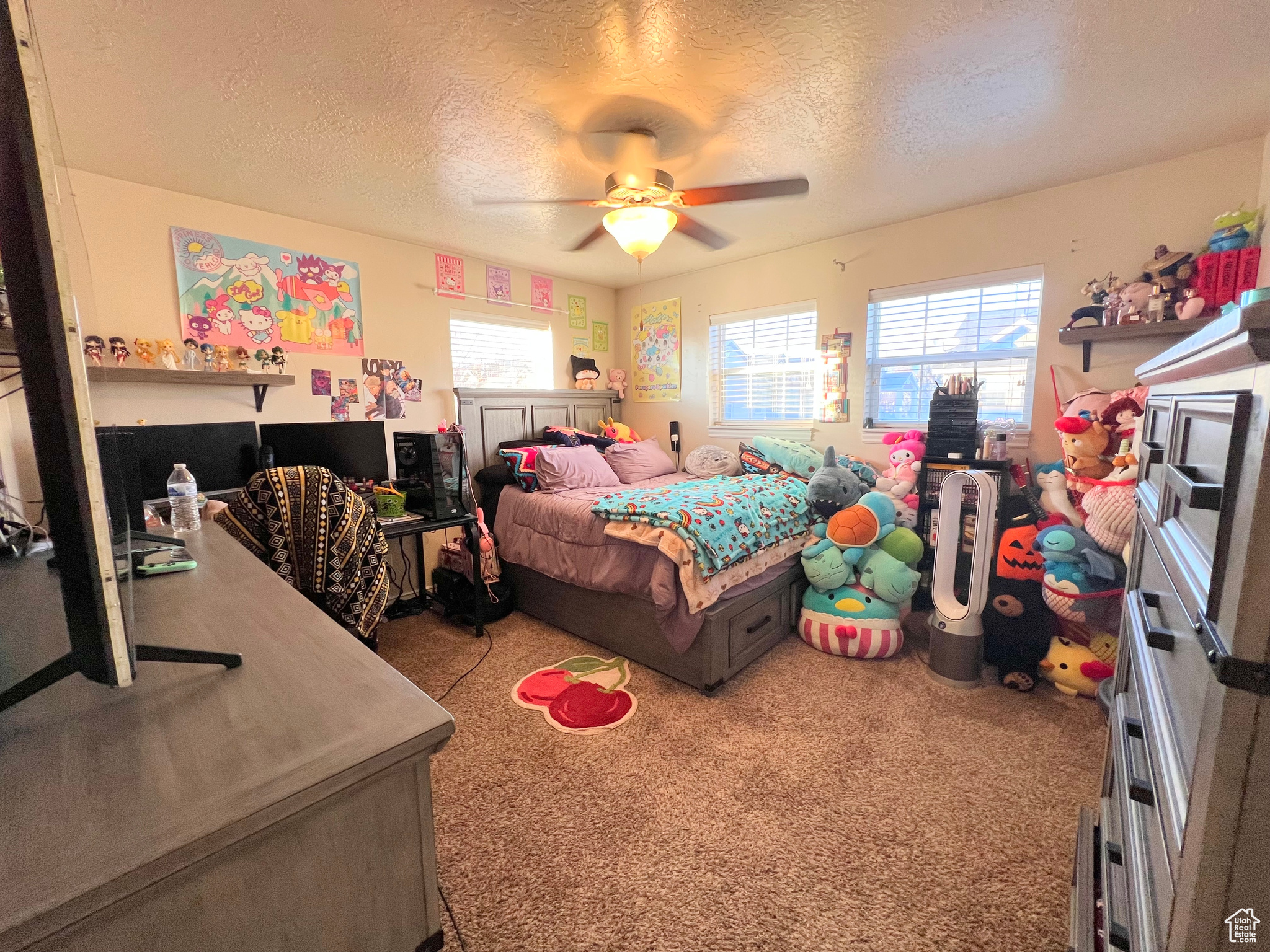 Carpeted bedroom featuring a textured ceiling and ceiling fan