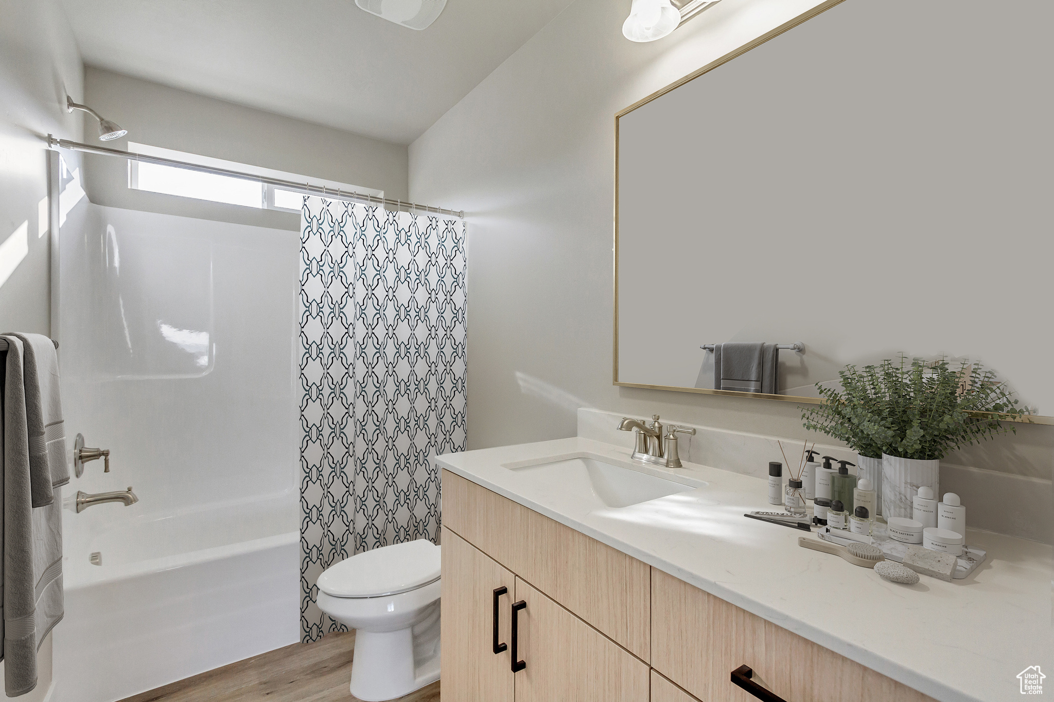 Full bathroom featuring hardwood / wood-style floors, vanity, toilet, and shower / bath combo