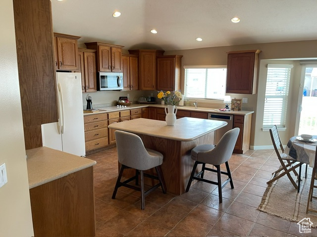 Kitchen featuring a kitchen breakfast bar, a center island, sink, and appliances with stainless steel finishes