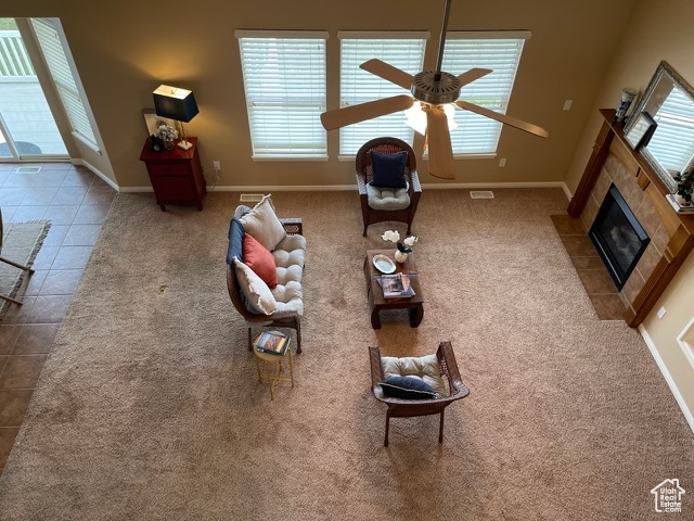 Unfurnished living room with tile patterned flooring, ceiling fan, and a tile fireplace