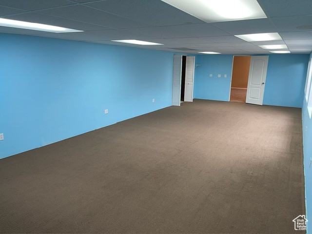 Basement featuring a paneled ceiling and carpet floors