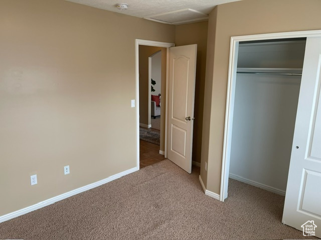 Unfurnished bedroom with a closet and light colored carpet