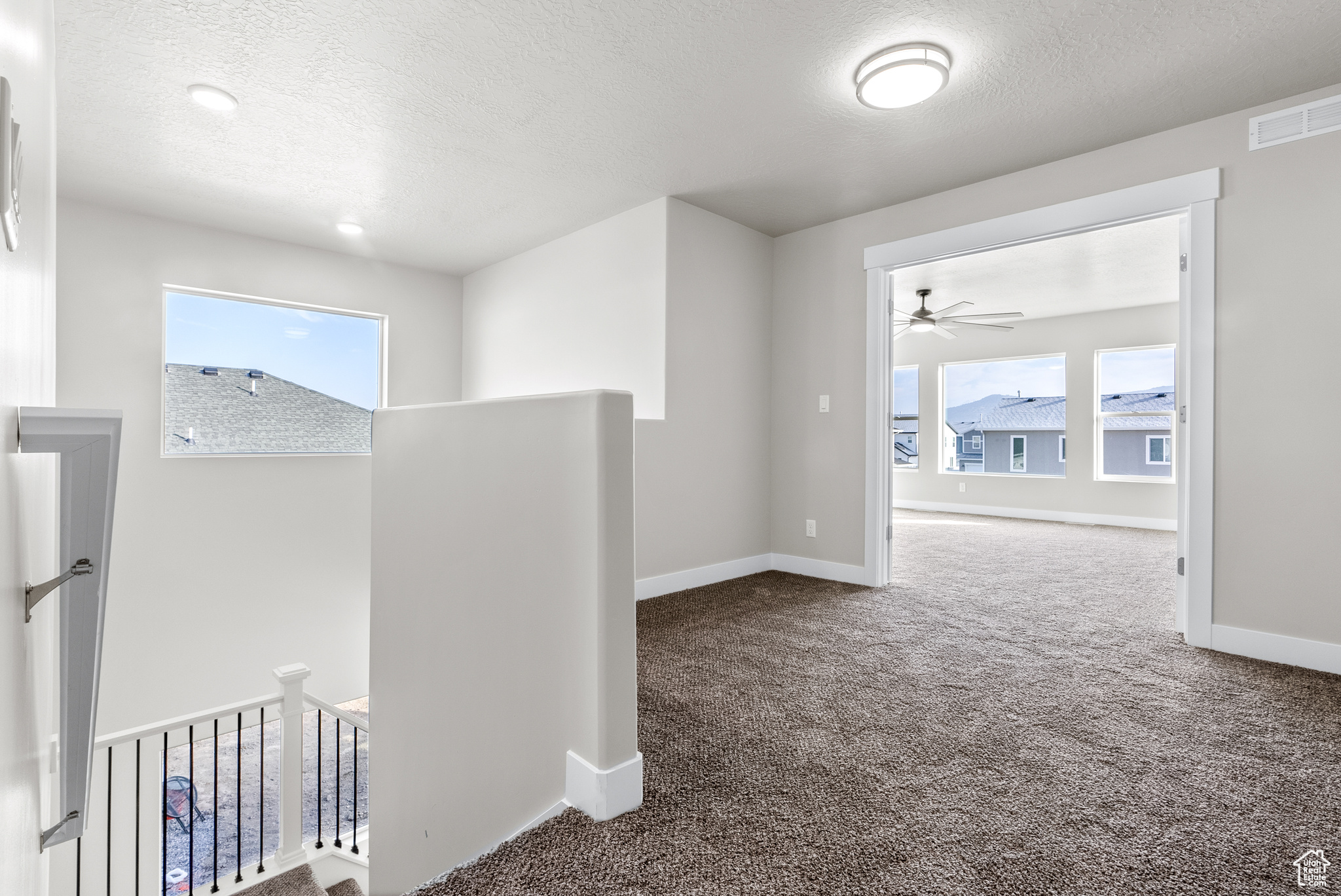 Hall featuring carpet floors and a textured ceiling