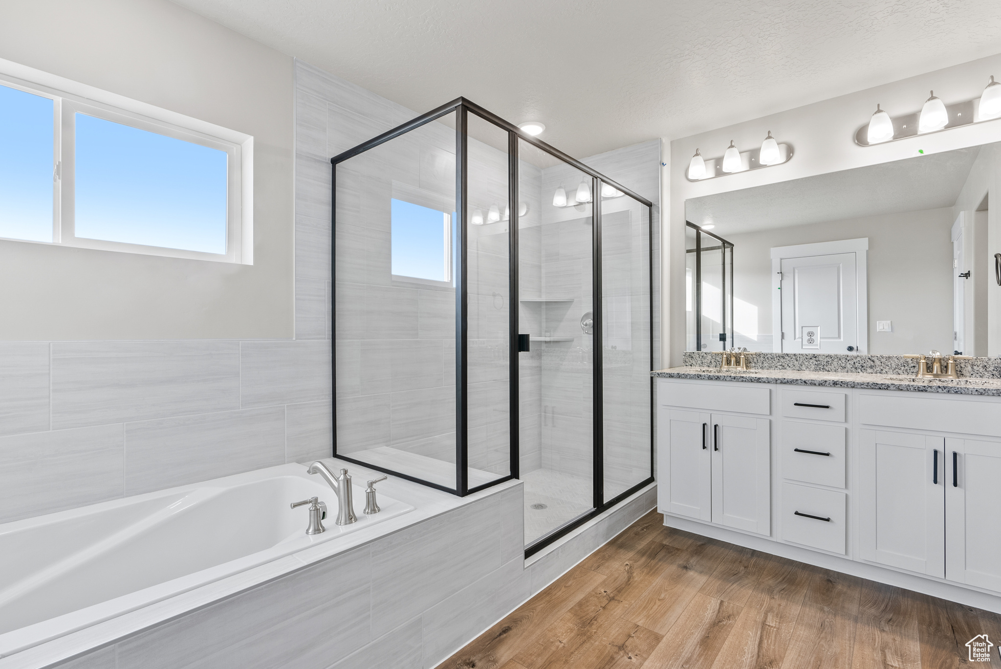 Bathroom with independent shower and bath, vanity, and wood-type flooring