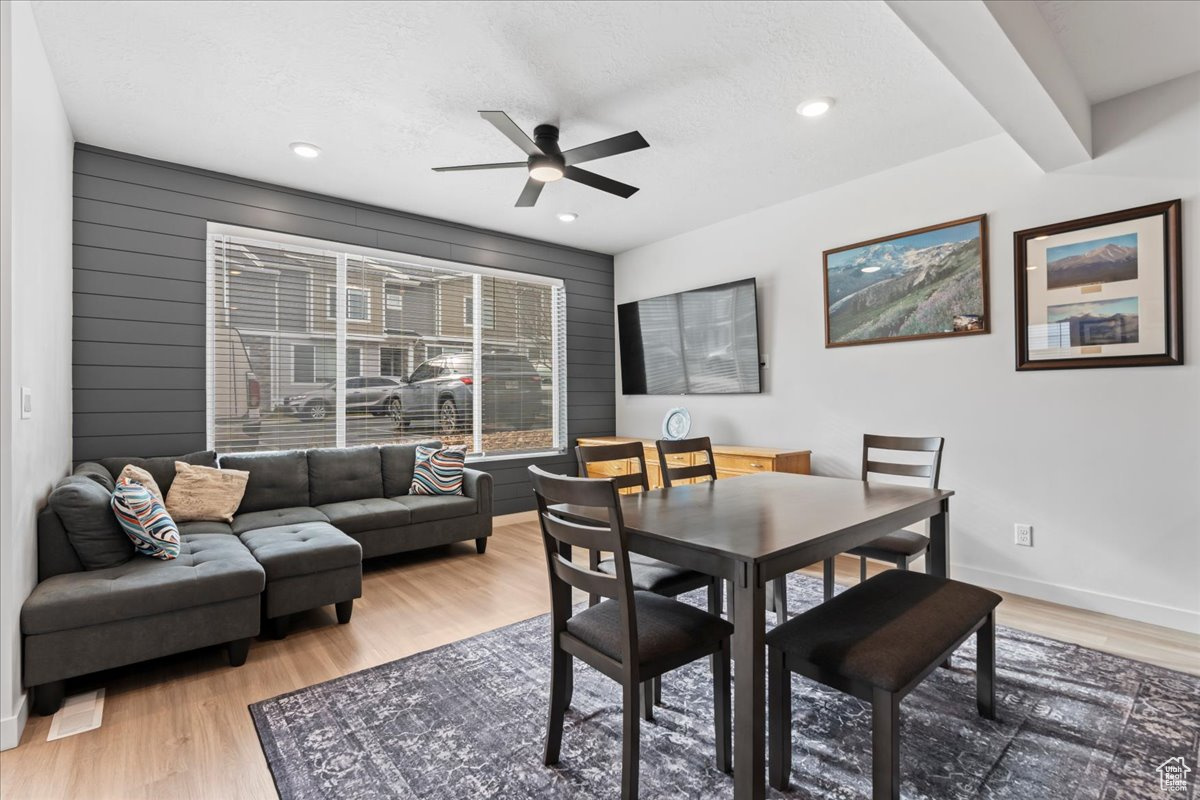 Dining space featuring beam ceiling, ceiling fan, a textured ceiling, and hardwood / wood-style flooring