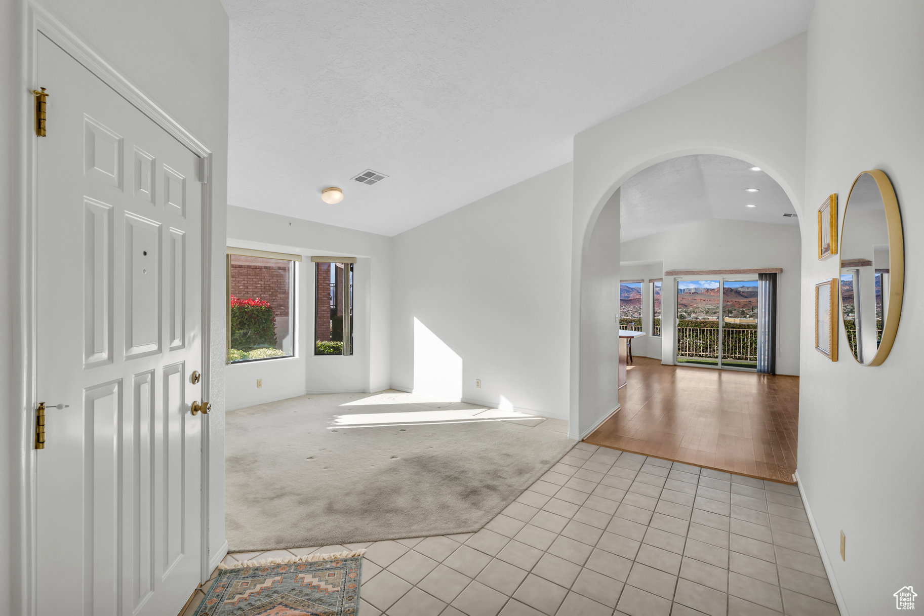 Foyer entrance with lofted ceiling, a healthy amount of sunlight, and light tile patterned floors