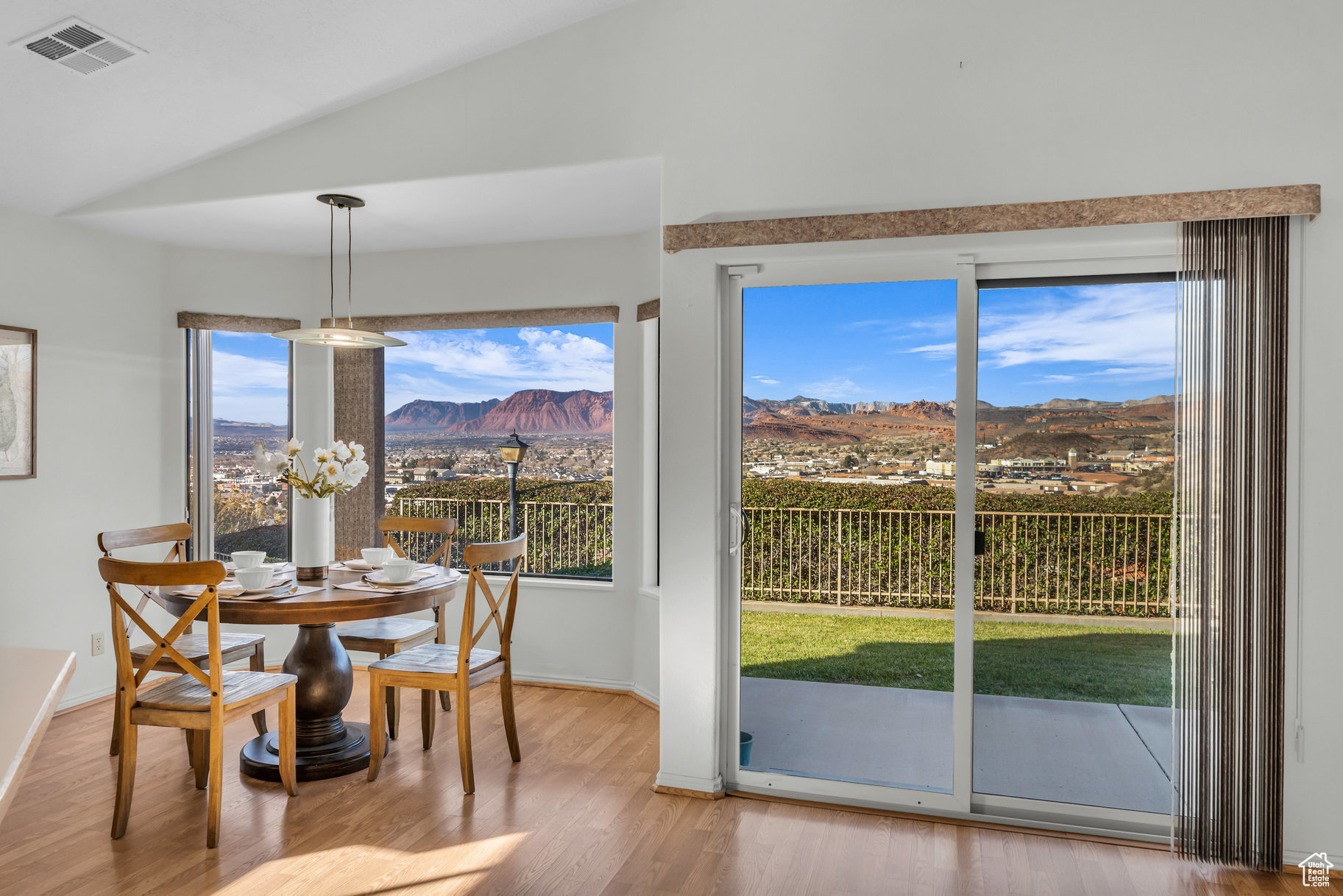 Dining area featuring a mountain view, lofted ceiling, a wealth of natural light, and light hardwood / wood-style flooring