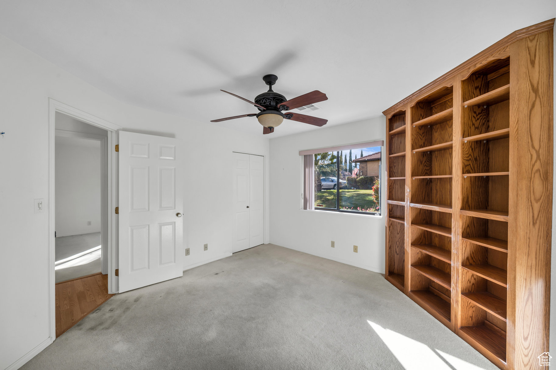 Unfurnished room with ceiling fan and light colored carpet