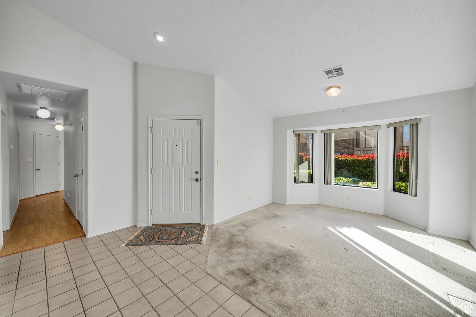 Tiled entryway featuring vaulted ceiling