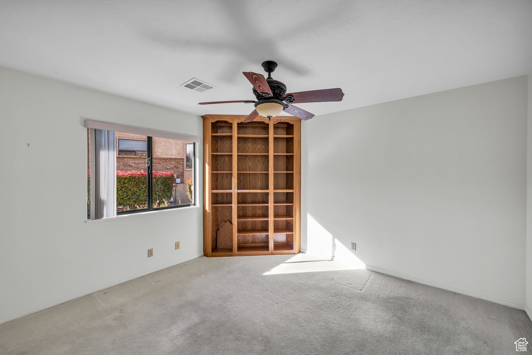 Unfurnished room with ceiling fan and light colored carpet