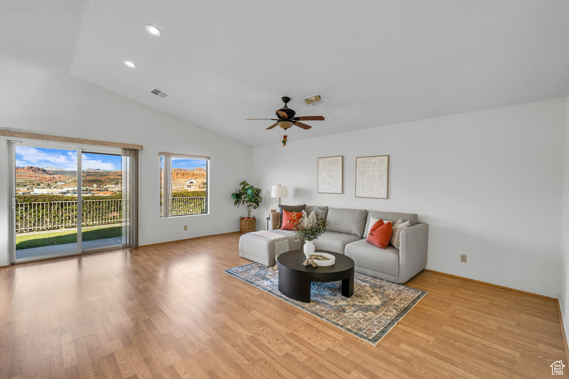 Living room featuring ceiling fan, light hardwood / wood-style floors, and lofted ceiling