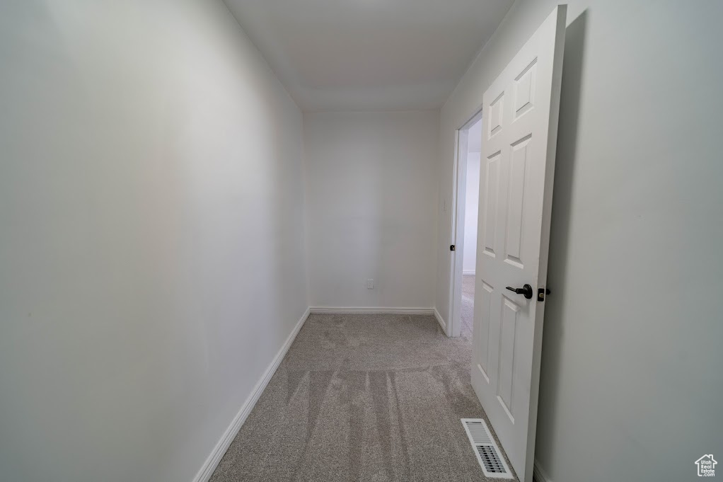 Hall featuring light colored carpet