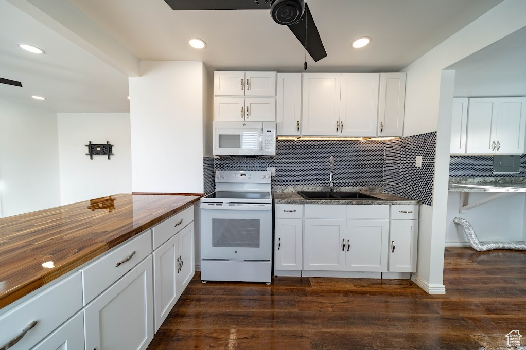 Kitchen featuring white appliances, sink, butcher block countertops, white cabinetry, and dark hardwood / wood-style floors