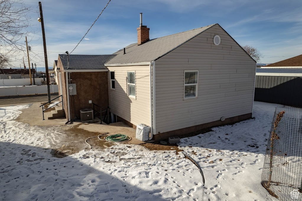 View of snow covered exterior with central AC