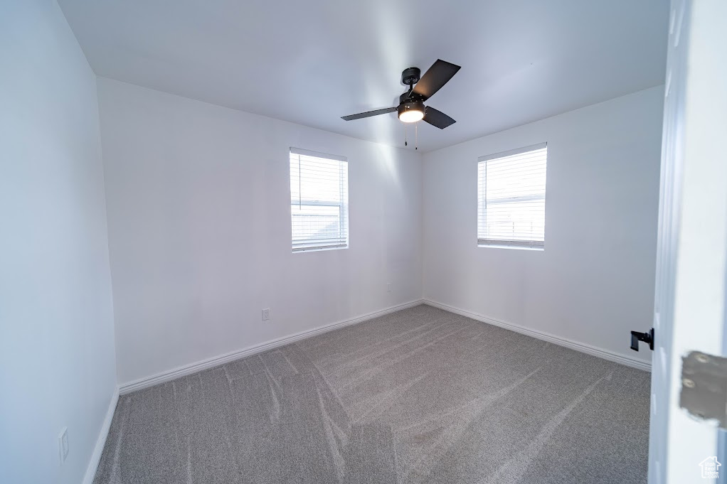 Carpeted empty room with ceiling fan