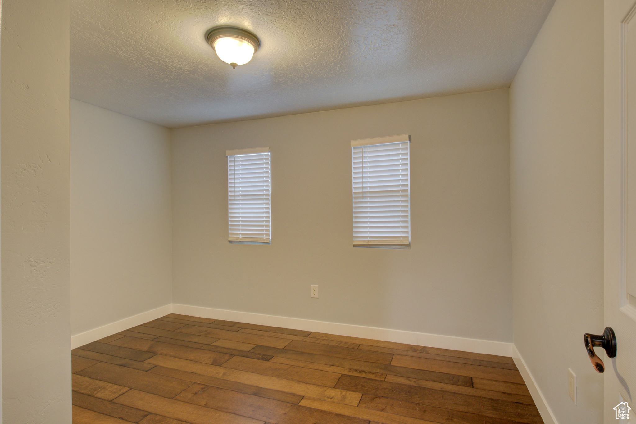 Unfurnished room featuring a textured ceiling and hardwood / wood-style flooring