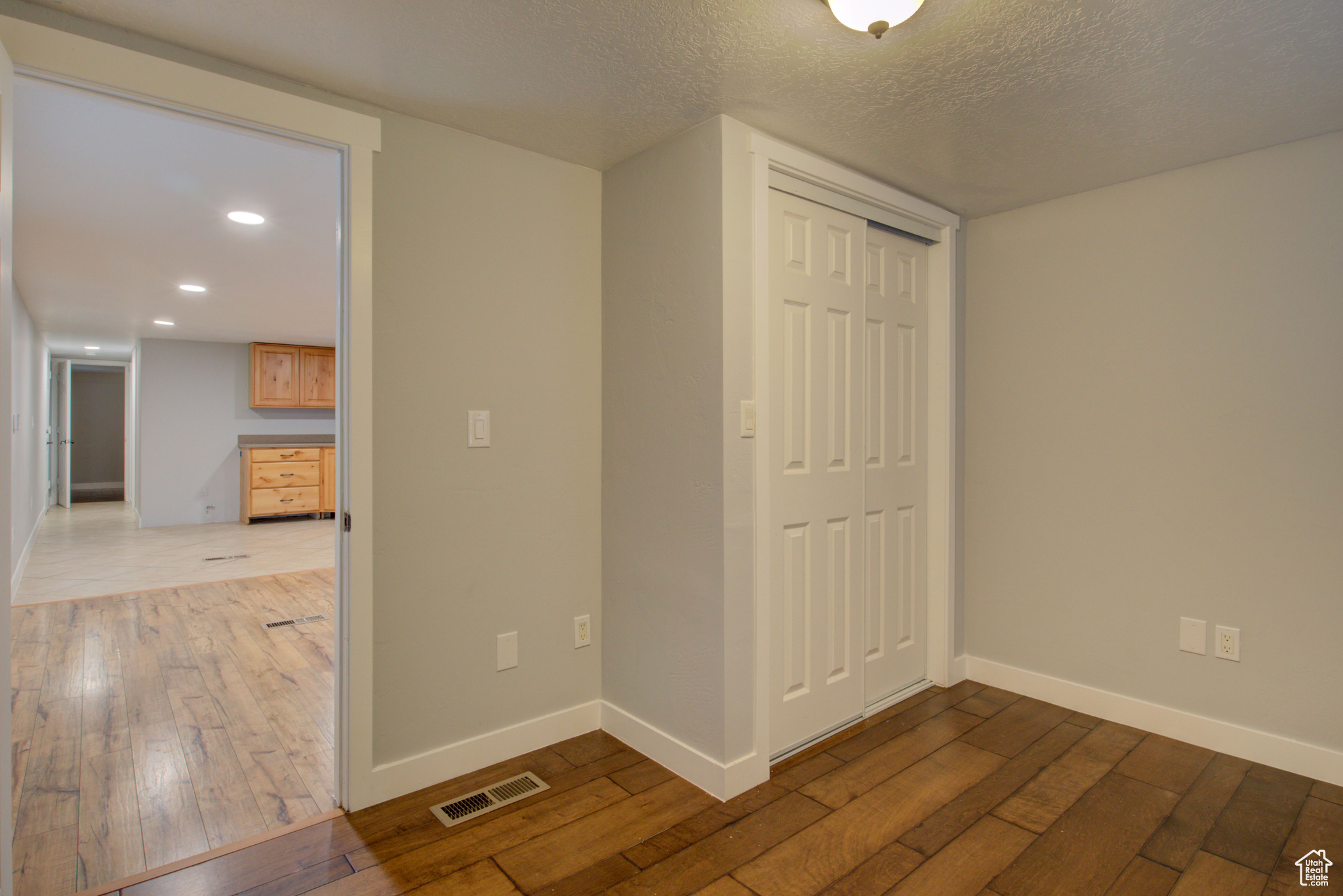 Interior space featuring a textured ceiling, light hardwood / wood-style floors, and a closet